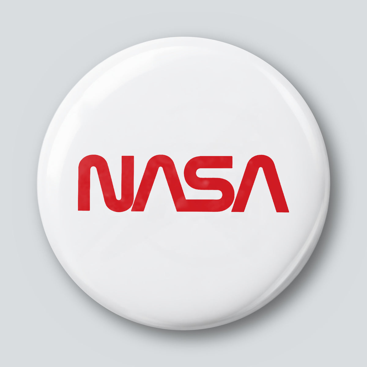 Round 25 mm pin with the red NASA worm logotype on a white face
