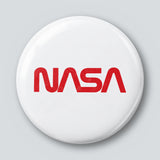 Round 25 mm pin with the red NASA worm logotype on a white face